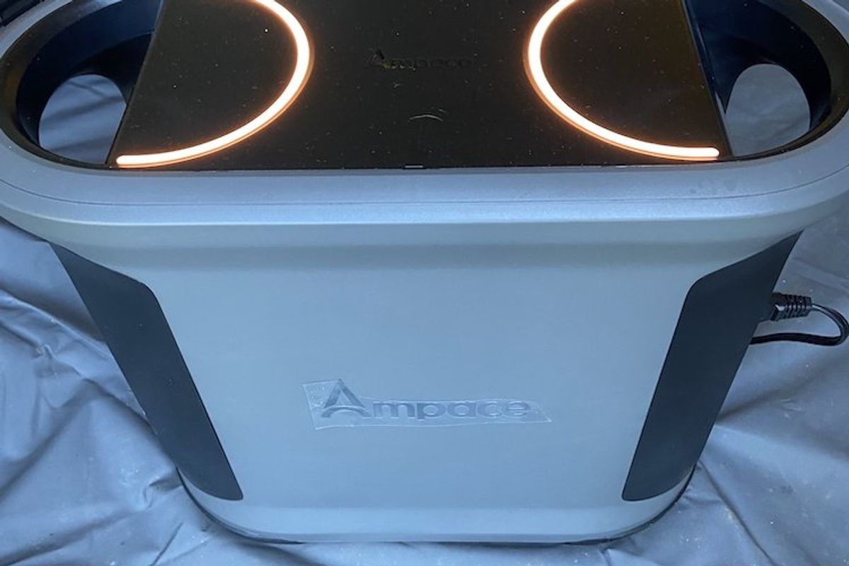 a photo of Ampace Andes 1500 in a tent powering up a inflattable mattress.